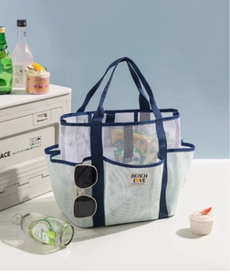 Detail of white mesh beach bag with multi-pockets, blue straps and inner sunglasses