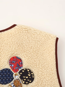 Detailed view of beige faux shearling vest with colorful vintage patchwork motif