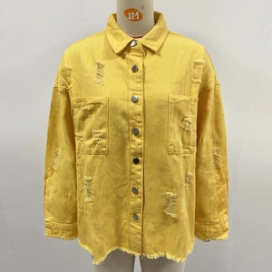 Detail of yellow distressed denim jacket featuring metal buttons and frayed hem edge