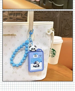 Primo piano di un simpatico portachiavi puzzle a scorrimento con panda su borsa bianca.