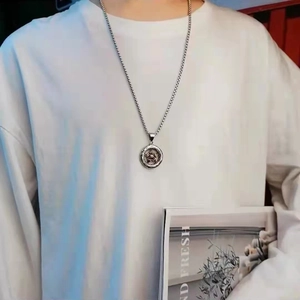 Detail of a silver star pendant necklace worn by a model in casual white t-shirt