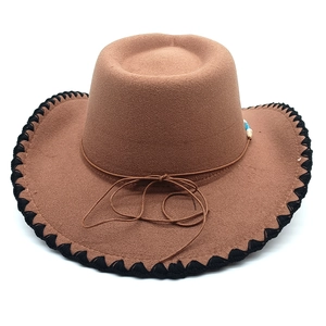 Detail of brown wool felt cowboy hat with black braided trim and beaded rope decoration