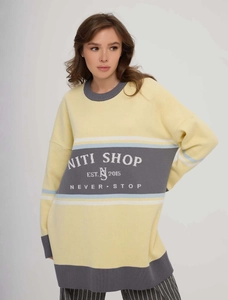 Loose knit sweater with yellow and grey patchwork and letter print on front