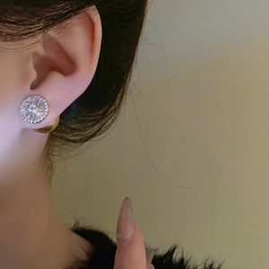 Gros plan d'élégantes boucles d'oreilles dorées en rayons de soleil avec zircons