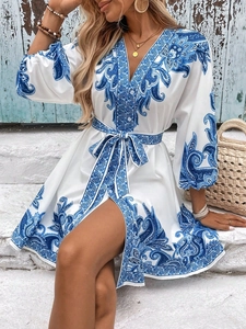 Detail of V-neckline and paisley print on blue and white summer mini dress with waist tie