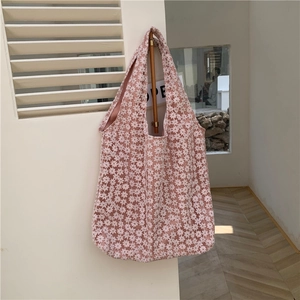 Detail of pink floral lace shoulder bag with intricate embroidery and fabric lining