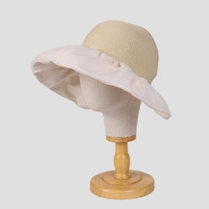 Detailed close-up of woven straw crown and smooth satin wide brim on sun hat