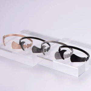 Detail of four irregular bangles in rose gold, silver, gunmetal, and matte black finishes