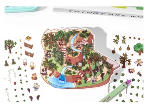 Detailed view of 3D forest scene animal stickers laid flat with stationery and pens