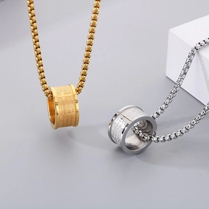 Detailed macro view of gold and silver cylinder pendants with engraved scripture verses