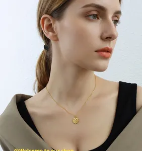 Close-up of a hollow Fu character round pendant on 18K gold plated titanium necklace