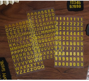 Dettaglio macro di lettere e numeri adesivi dorati su fondo in legno scuro