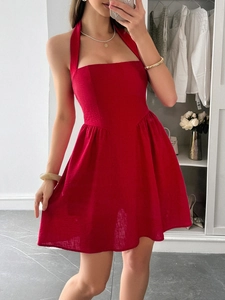 Close-up of elegant red halter neck backless A-line dress with pleated texture