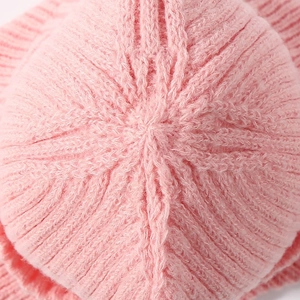 Close-up of the delicate pink knitted texture and craftsmanship on top of the winter hat