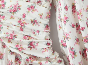 Close-up of floral V-neck dress showing delicate pleated texture and light chiffon fabric