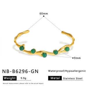 Detail of wavy gold bangle with five green pearls including size dimensions in millimeters
