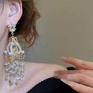 Detailed view of luxury crystal chandelier pearl tassel earrings with gold filigree