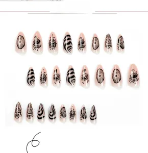 Detail view of almond press on nails with hand-painted black eye patterns and wavy lines