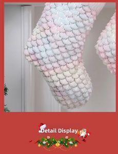 Makroaufnahme von Weihnachtsstrumpf mit pastellfarbenem Kunstfell und silbernen Fischschuppen