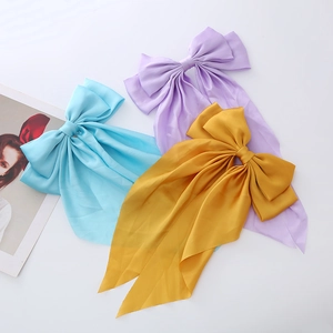 Three elegant satin bow hair clips in blue, purple, and yellow with long streamers