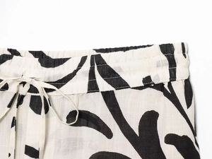 Detail of elastic waist with drawstring on black and white floral print trousers