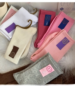 Gros plan de chaussettes en coton côtelé avec patchs sourire sur fond en peluche