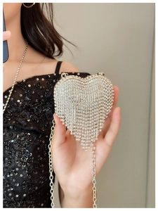 Macro shot of silver heart evening bag with sparkling rhinestones and metal chain