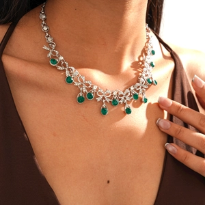 Macro detail of silver necklace featuring green waterdrop stones and tassel rhinestones