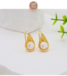 Detail of bird nest design earrings with natural pearls and 18k gold plated silver hooks
