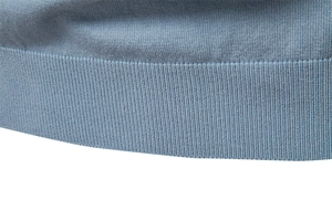 Detail of high-density ribbed cuff on grey-blue knitted polo shirt with fine texture