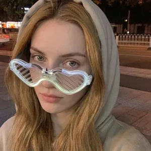 Close-up of heart-shaped LED shutter glasses worn by a person at a night party
