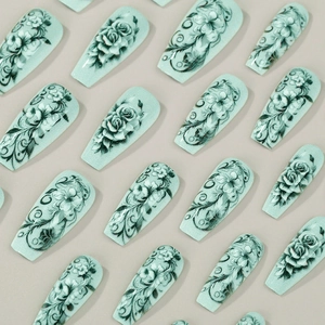 Mint green coffin press-on nails with delicate black rose patterns and glossy finish