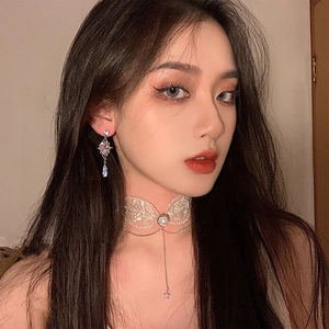 Detail of baroque drop earrings with purple zircon and a white lace choker necklace