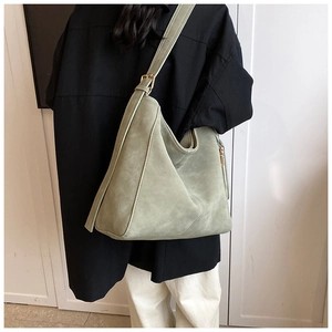 Detailed view of sage green matte suede tote bag with contrast stitching and metal buckle