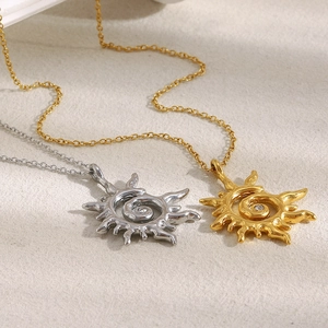 Colliers pendentifs soleil 18K or et argent avec zircon sur tissu beige texturé