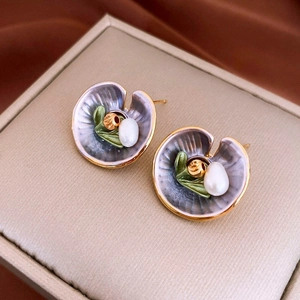 Macro detail of enamel leaf earrings with blue-purple gradient and white pearl accent