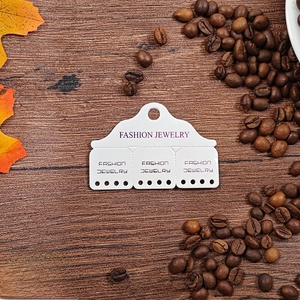 White jewelry display card with purple Fashion Jewelry text on dark wood background