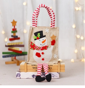 Detail of Christmas snowman candy bag made of burlap with red striped handles and legs
