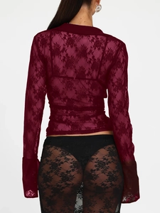 Detail view showing the intricate floral lace pattern on the back of a dark red cardigan