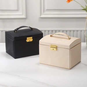 Close-up of luxury leather jewelry boxes in black and cream with gold metal locks