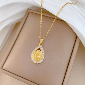Detail of gold teardrop necklace with Virgin Mary pendant and sparkling zircon stones