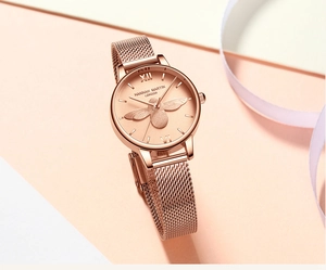 Détail d'une montre en or rose avec relief d'abeille 3D et bracelet à mailles milanaises