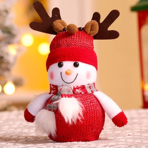 Close-up of a red knit Christmas snowman doll with reindeer antlers and a cozy scarf