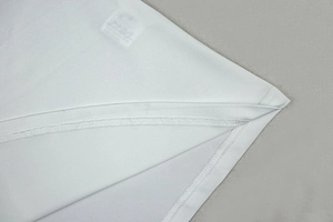 Vue détaillée du tissu en jersey blanc montrant la finition à double aiguille