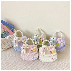 Detail of girls floral lace mini bags with pearl handles and cute plush bear pendants