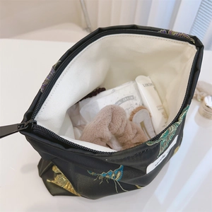 Macro detail of Chinese style butterfly jacquard makeup bag with gold embroidery and lining