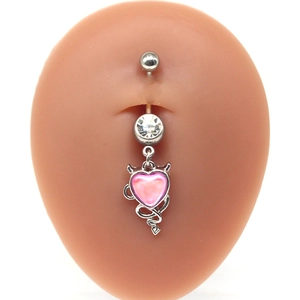 Detailed close-up of pink heart devil wing belly ring with sparkling zircon inlays