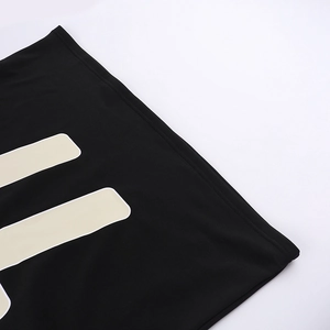 Close-up of black streetwear hoodie fabric showing texture and cream white printed patterns