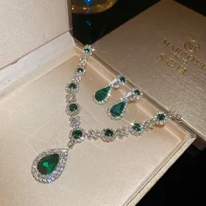 Elegant emerald teardrop necklace and earrings set in a premium velvet gift box