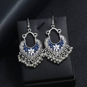 Detail view of silver vintage earrings with blue enamel flowers and tassels